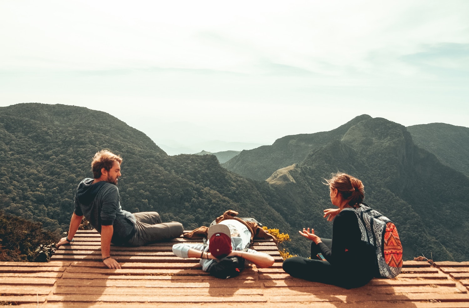 Three friends hanging out on a mountain top